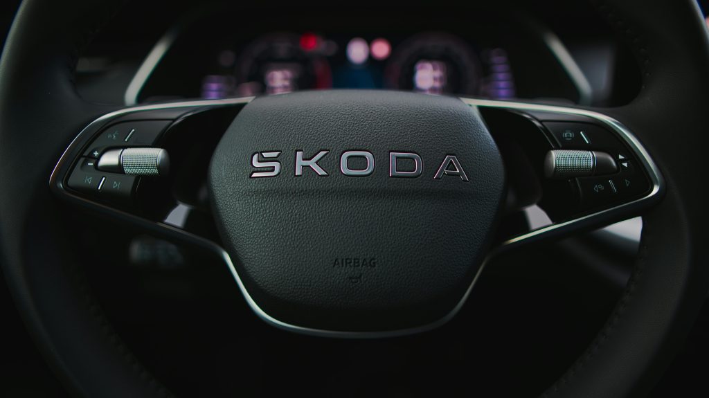 Detailed image of a Škoda steering wheel highlighting controls and dashboard.